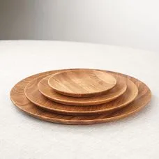 Деревянная тарелка с выпечкой и круассанами, рядом пшеничные колоски.