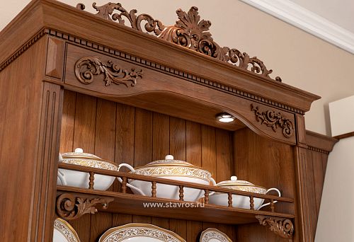 Фрагмент деревянного шкафа с резным декором, покрытого морилкой или лаком, классический орнамент ручной работы