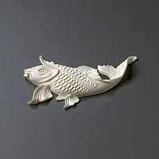 Luxurious chest of drawers with golden fish stucco in the room's interior.