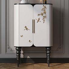Close-up of white cabinet doors decorated with golden NPU-481 molding in the shape of butterflies and dragonflies.