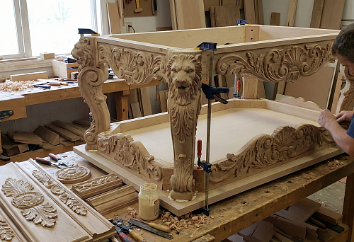Сборка резного мебельного каркаса стола в мастерской: накладки с орнаментом и львиные маскароны на ножках