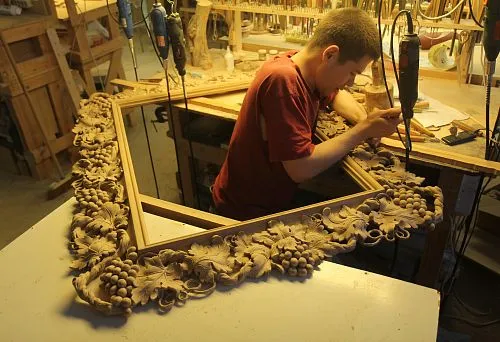 Мастер создаёт интерьерную композицию с резной рамой и деревянными элементами