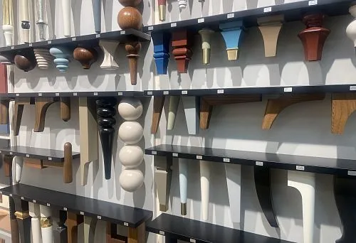 Various wooden furniture legs on display, showcasing elegant shapes and finishes.