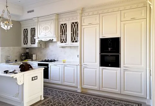 Elegant kitchen with built-in appliances and marble countertop.