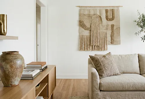 Decorative interior accents without clutter &mdash; a neutral living room with a panel, ceramic vase, and accent pillow