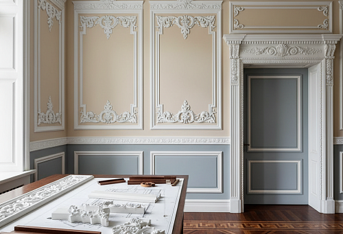Interior with decorative moldings, contour profiles, and wall layouts, as well as a table with architectural decor samples.