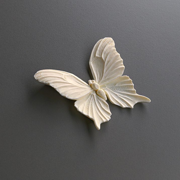 Room interior with a white chest of drawers decorated with polyurethane molding NPU-479 in the form of butterflies