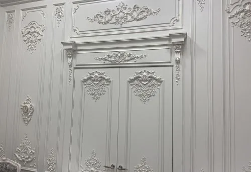 Snow-white decorative door frame molding with stucco decor and elegant ornaments in classic style