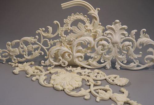 Ceiling molding under the chandelier &mdash; complex white decorative elements made of polyurethane with pronounced relief