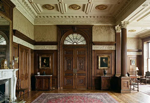 Luxurious interior with carved doors, columns, and wall panels
