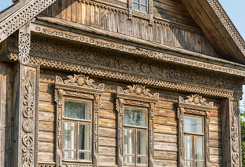 Wooden Patterns on Houses: Carved Window Frames, Cornices, and Ornaments of Russian Architecture on a Wooden House Facade