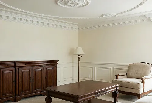 Decorative polyurethane elements on the ceiling and walls in a classic living room with wooden furniture