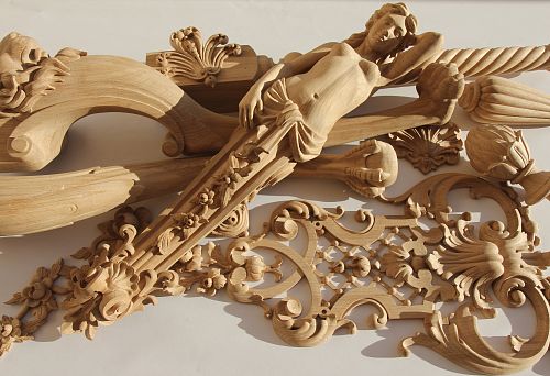Decorative wooden carved elements, including a female figure and complex ornaments