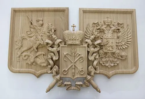 Carved wooden coat of arms featuring a double-headed eagle, Saint George slaying a dragon, and symbols of Saint Petersburg