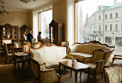 Classic furniture in a showroom: sofas and armchairs with carved decor, display cases and tables, Moscow