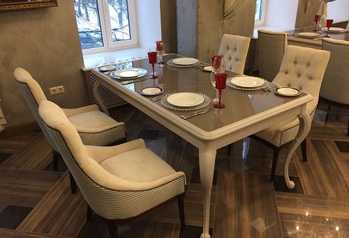 Classic white dining table with curved legs and serving set.