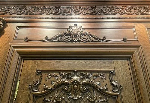 Decorative wooden doorway framing with carved ornament in classical style