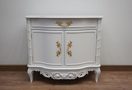 White carved chest of drawers with gilded decorative elements in a classic style