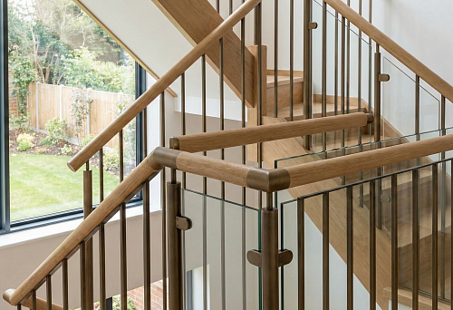 Modern staircase 2026 with round wooden handrails and metal balusters