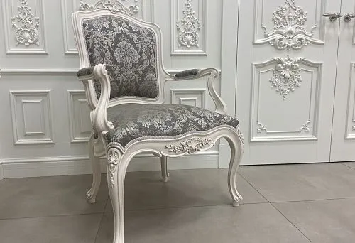 Elegant wooden chair with intricate carving and soft upholstery, showcasing handcrafted skill.