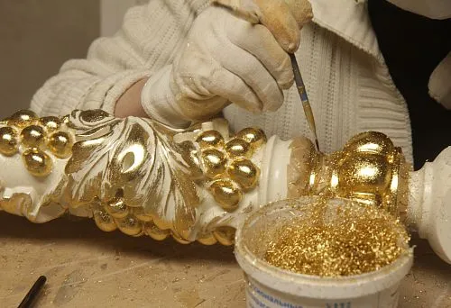 Artistic decoration of decorative element with gold finish &mdash; manual gilding process.