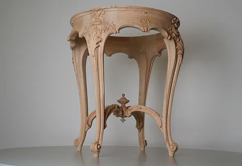 Round wooden base with hand-carved details, curved legs and decorative element in the center