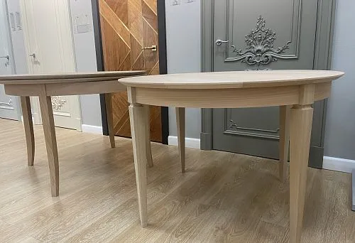 The photo shows two round tables made of natural wood with elegant legs, demonstrating a sturdy frame and refined design.