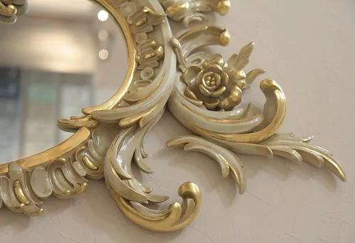 Elegant interior decor: exquisite carving with gold on a mirror frame.