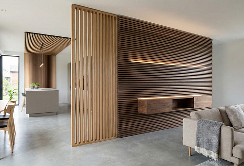 Modern living room with an accent wall made of dark wooden interior slats and built-in lighting