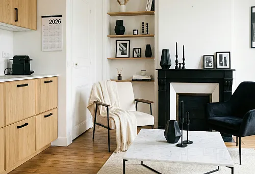 Modern kitchen with black furniture handles on light wooden facades