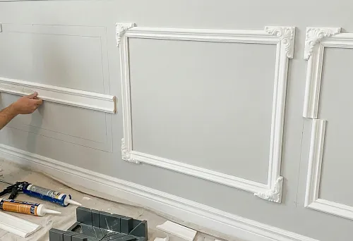 Polyurethane stucco on the wall and polyurethane molding &mdash; assembling a classic panel without plaster: the master glues the molding according to the markings