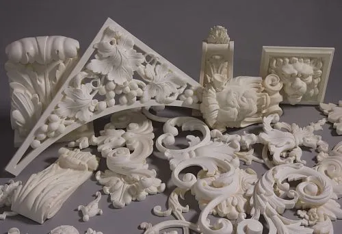 Set of decorative molding elements in classic style: scrolls, leaves, lion masks, and architectural forms, in light tones.