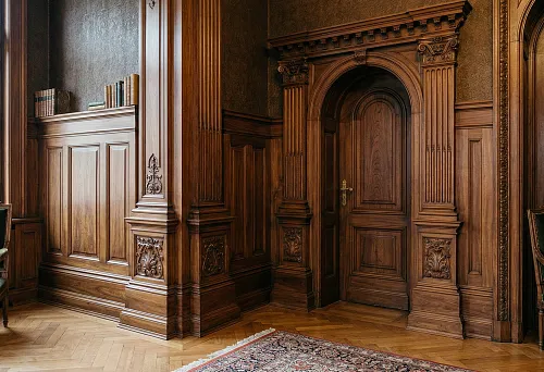 Wooden baseboard and pilasters in a classic interior: unified wall and door frame finishing