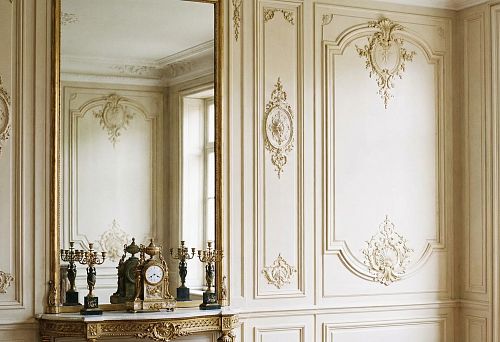 Image of a classic interior with light walls decorated with moldings and decorative overlays