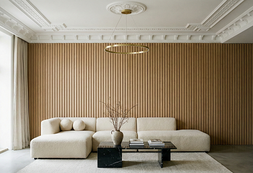 Modern living room with slatted wall and ceiling molding &mdash; decorative elements in interior style