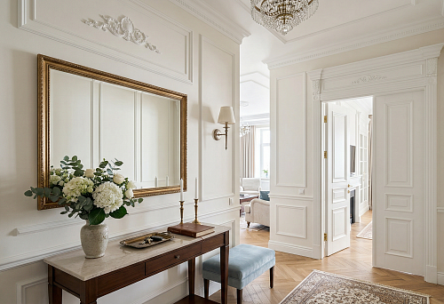 Hallway in neoclassical style: how to decorate walls with moldings, a mirror, and a portal without overloading