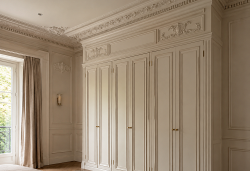 The top of the cabinet is not a gap or emptiness: how moldings and stucco turn built-in furniture into room architecture