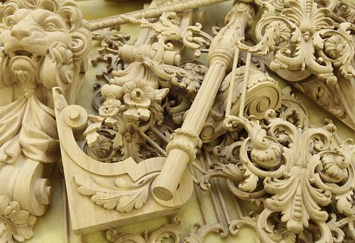 Set of hand-carved decorative elements from oak with floral, botanical, and figurative ornaments.