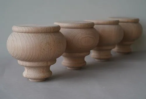 Four precisely crafted wooden furniture supports arranged in a row, showcasing the natural wood grain.