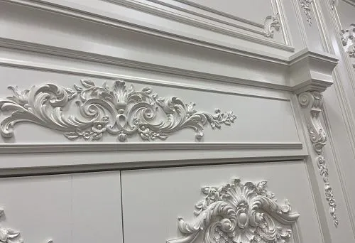 Door casing with white molded decoration and carved elements in classic style