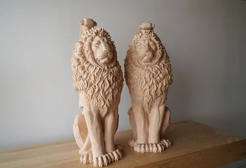 Pair of carved oak lions without finish on workbench &mdash; deep hand-carved work
