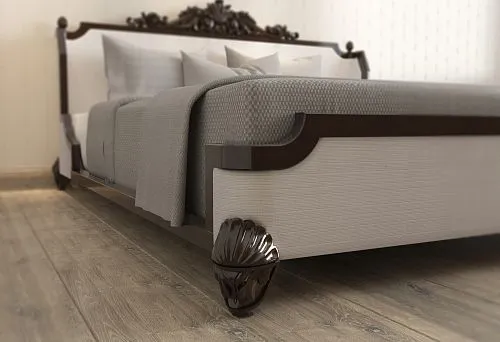 Wooden bed with dark headboard and carved elements on legs