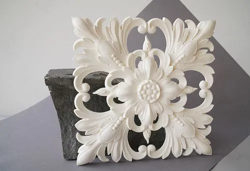 Polyurethane molding in the form of a rose under a chandelier on stone