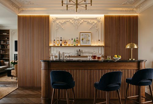 Stucco decor and wooden slats for a home bar: how to design a bar area in a unified style