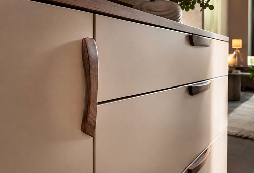 Wooden handles on cabinet facades in a modern interior