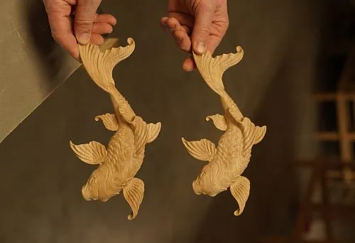 Two Carved Wooden Fish Figures, Reflecting the Craftsmanship of Handmade Work and Fine Detailing.