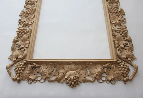 Luxurious carved frame made of natural wood, decorated with grape and leaf motifs.