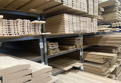 Shelf with wooden profiles and boards of different thicknesses and shapes, neatly arranged for storage