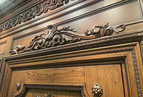 Sandro in architectural decoration above a wooden door frame