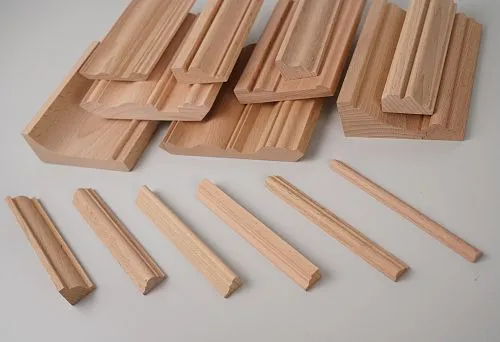 Set of wooden beams of different lengths and shapes, neatly arranged on a white background.